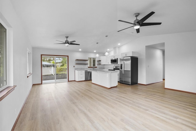 kitchen featuring a center island, hanging light fixtures, light wood-type flooring, appliances with stainless steel finishes, and white cabinetry