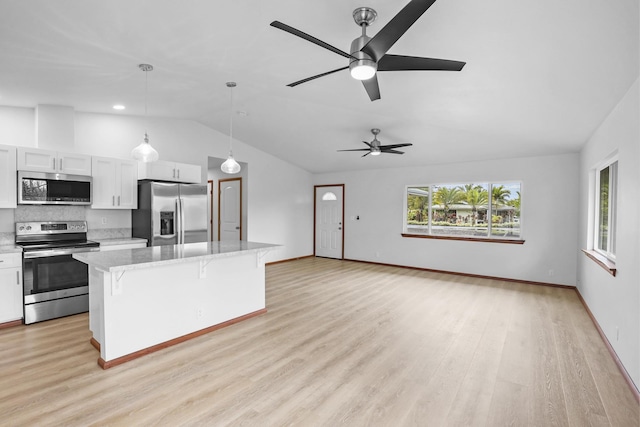 kitchen featuring pendant lighting, a center island, white cabinets, and stainless steel appliances