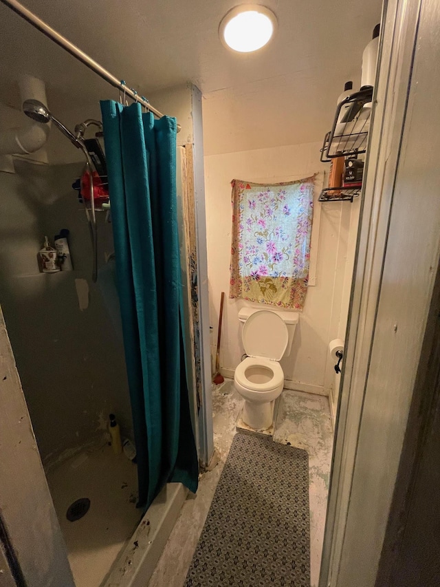 bathroom featuring curtained shower and toilet