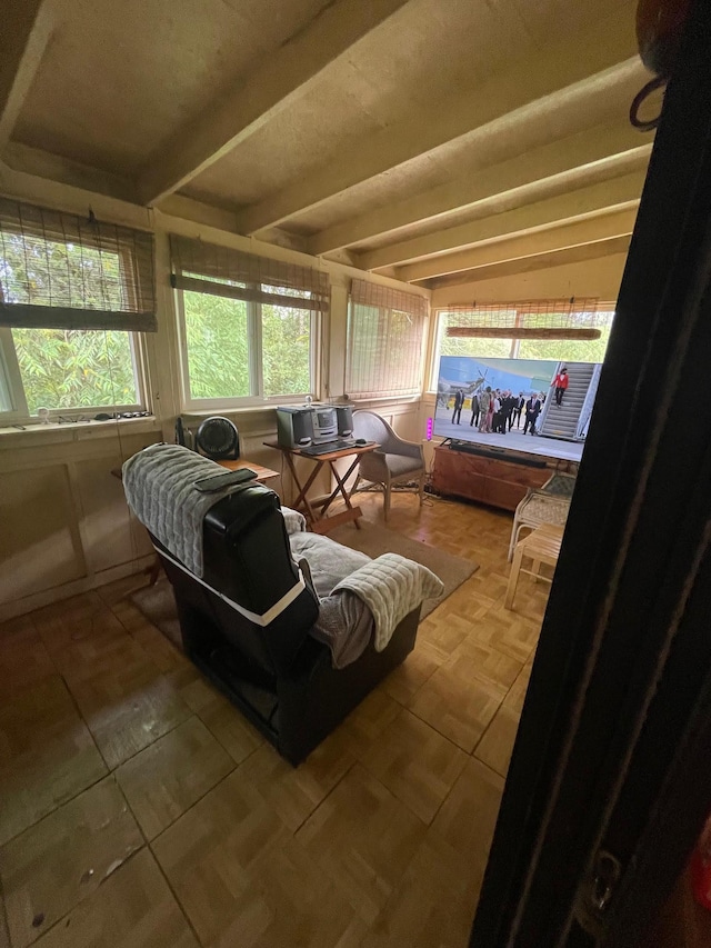 sunroom / solarium featuring beamed ceiling