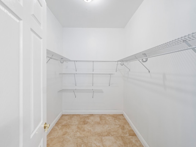 walk in closet featuring light tile floors