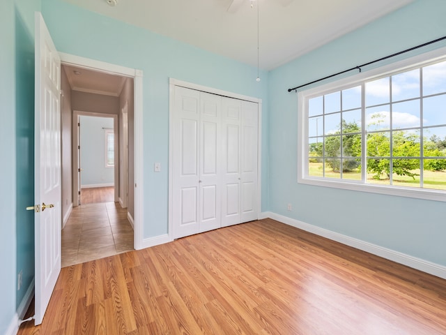 unfurnished bedroom with ceiling fan, a closet, and light tile flooring