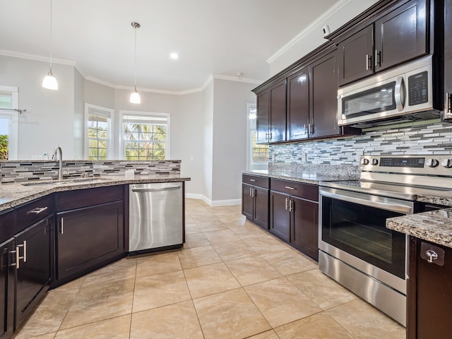 kitchen featuring light stone countertops, pendant lighting, backsplash, sink, and appliances with stainless steel finishes