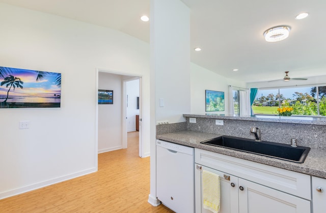 kitchen featuring dishwasher, white cabinetry, lofted ceiling, and sink