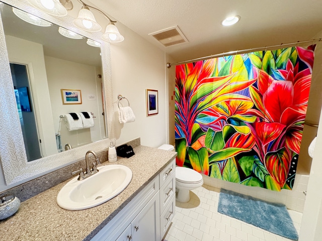 bathroom featuring tile patterned floors, vanity, and toilet