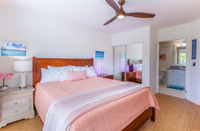 bedroom with ceiling fan, light hardwood / wood-style floors, ensuite bath, and a closet