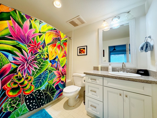 full bathroom with tile patterned floors, a textured ceiling, toilet, shower / bath combo with shower curtain, and vanity