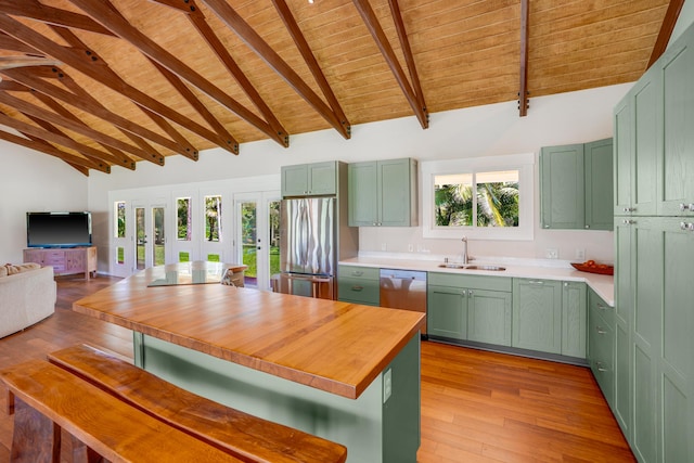 kitchen with wooden ceiling, green cabinets, sink, appliances with stainless steel finishes, and beamed ceiling