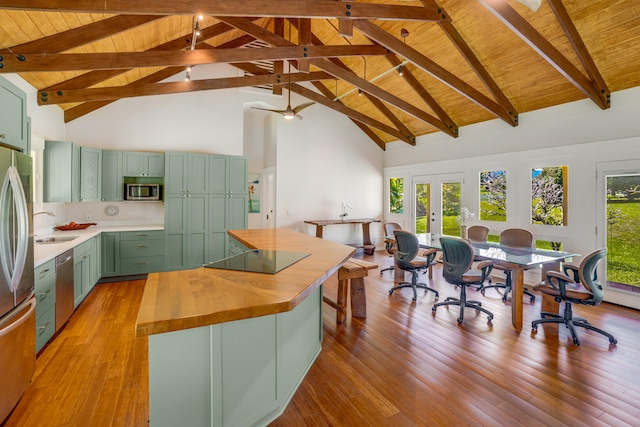 kitchen featuring wood counters, appliances with stainless steel finishes, high vaulted ceiling, beamed ceiling, and green cabinets