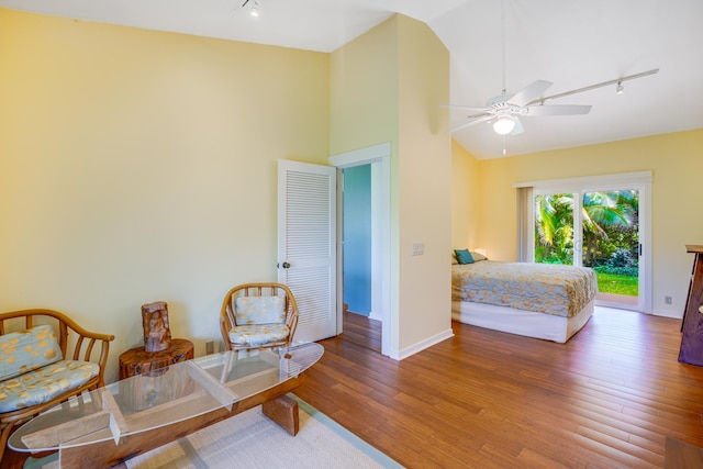 bedroom featuring access to exterior, hardwood / wood-style floors, track lighting, and ceiling fan