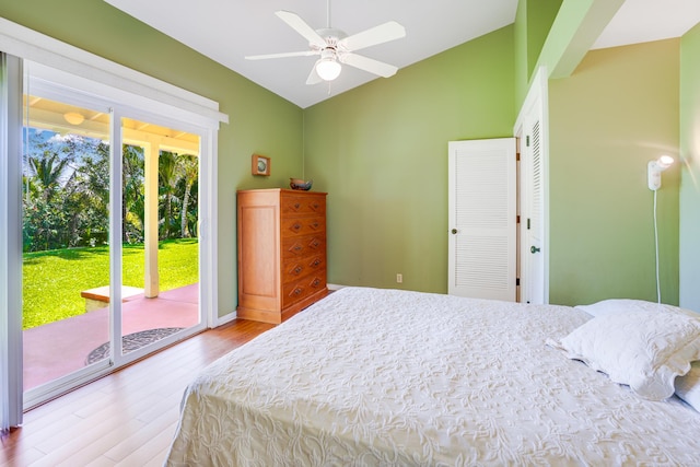 bedroom featuring access to outside, vaulted ceiling, hardwood / wood-style flooring, ceiling fan, and a closet