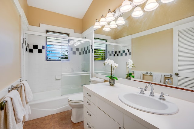 full bathroom featuring tile patterned floors, toilet, combined bath / shower with glass door, and vanity