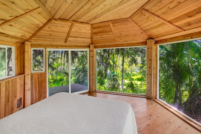 bedroom featuring hardwood / wood-style flooring, wood ceiling, wooden walls, and vaulted ceiling