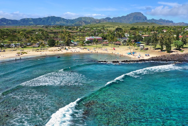 exterior space featuring a water and mountain view and a view of the beach