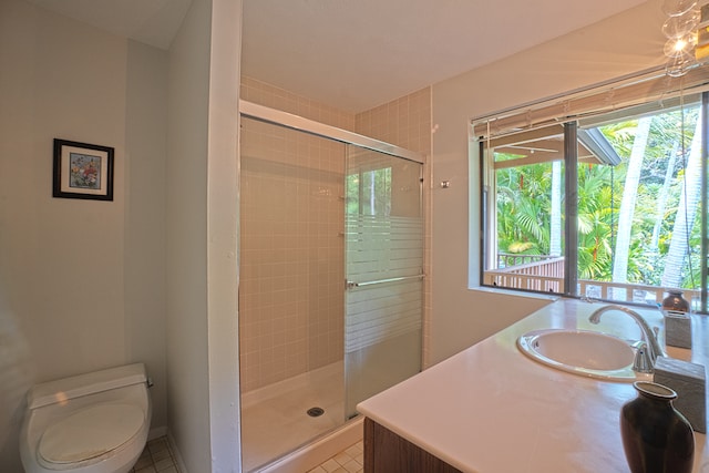 bathroom featuring a shower with shower door, vanity, tile patterned floors, and toilet