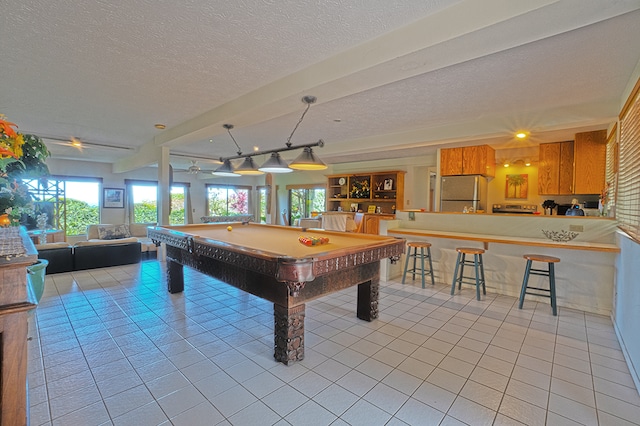 game room featuring a textured ceiling, light tile patterned floors, and billiards