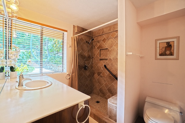 bathroom featuring a shower with curtain, toilet, vanity, and a textured ceiling