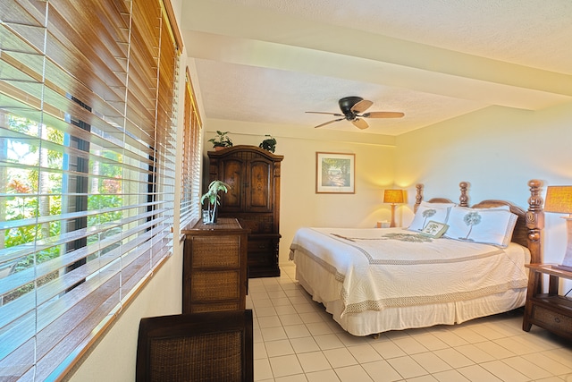 bedroom with a textured ceiling, ceiling fan, and light tile patterned floors