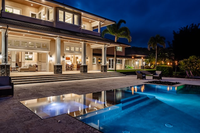 pool at twilight featuring a patio and an outdoor living space