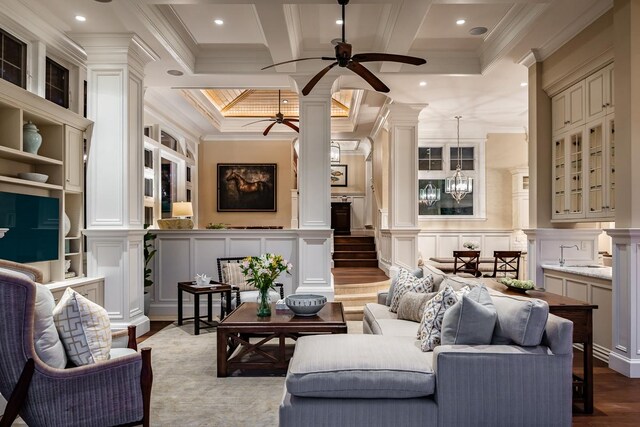 living room featuring ceiling fan, wood-type flooring, ornamental molding, and coffered ceiling