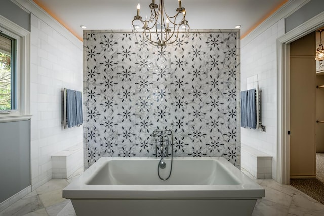 bathroom featuring a tub to relax in, marble finish floor, a notable chandelier, and tile walls