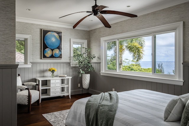 bedroom featuring dark wood-type flooring, ornamental molding, ceiling fan, and a water view