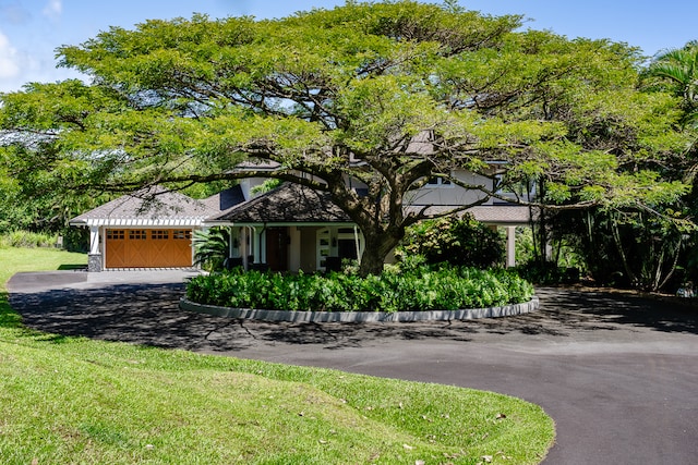 view of front of home with a garage and a front lawn