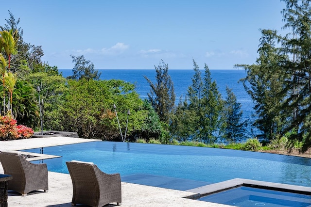 view of pool featuring a water view and an in ground hot tub