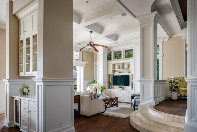 interior space featuring a decorative wall, dark wood-style flooring, beam ceiling, decorative columns, and crown molding