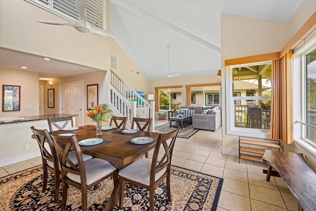 tiled dining room featuring ceiling fan and high vaulted ceiling