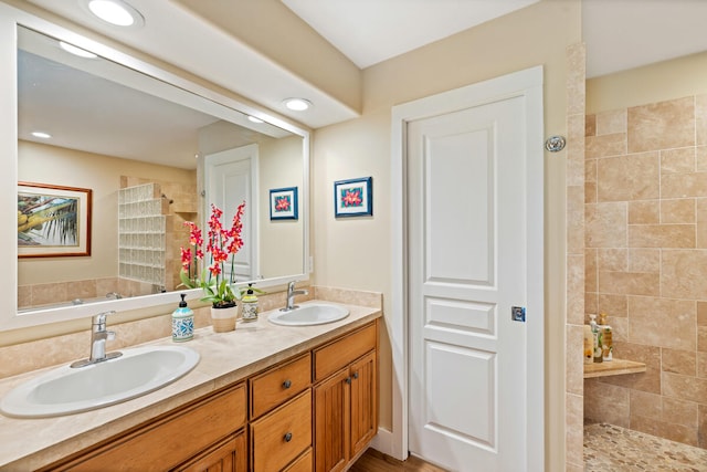 bathroom featuring a tile shower and vanity