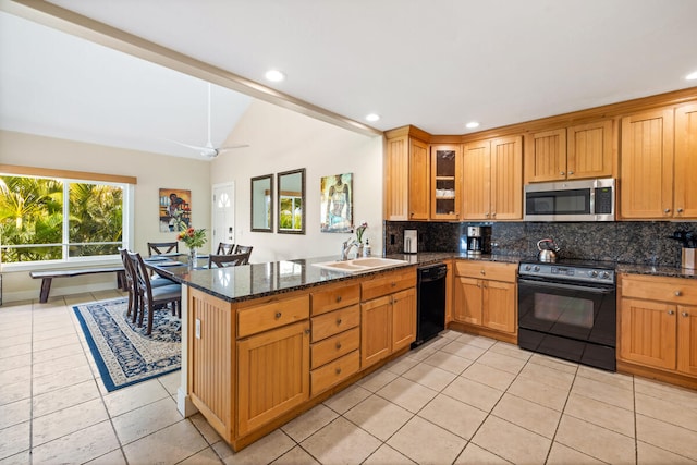 kitchen featuring sink, kitchen peninsula, dark stone countertops, light tile patterned floors, and black appliances