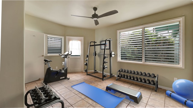 exercise room featuring light tile patterned floors and ceiling fan