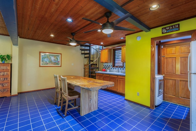 kitchen with decorative backsplash, dark tile patterned floors, a breakfast bar area, and wooden ceiling