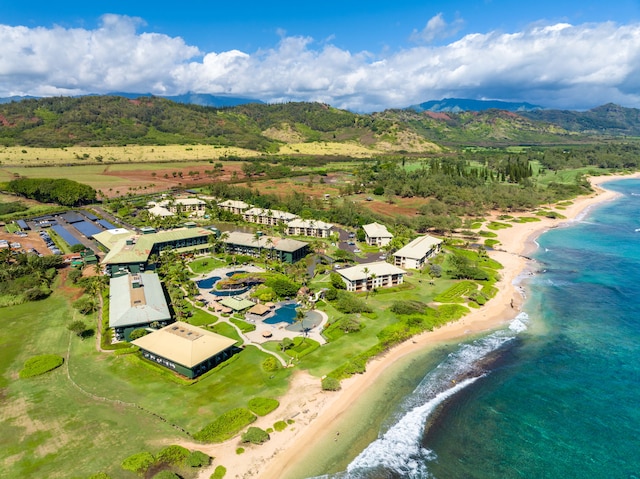 drone / aerial view featuring a water and mountain view and a view of the beach