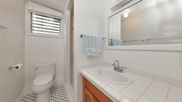 bathroom featuring a shower, vanity, and toilet