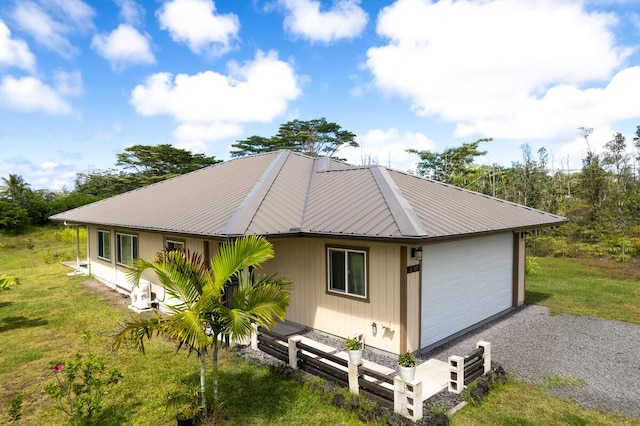 rear view of house with a yard and a garage