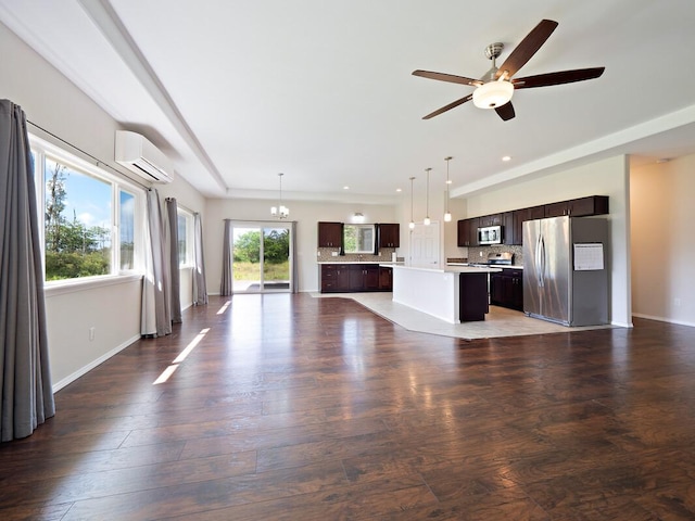 unfurnished living room with an AC wall unit, dark hardwood / wood-style flooring, and ceiling fan with notable chandelier