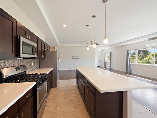 kitchen featuring an AC wall unit, decorative light fixtures, stainless steel appliances, decorative backsplash, and ceiling fan