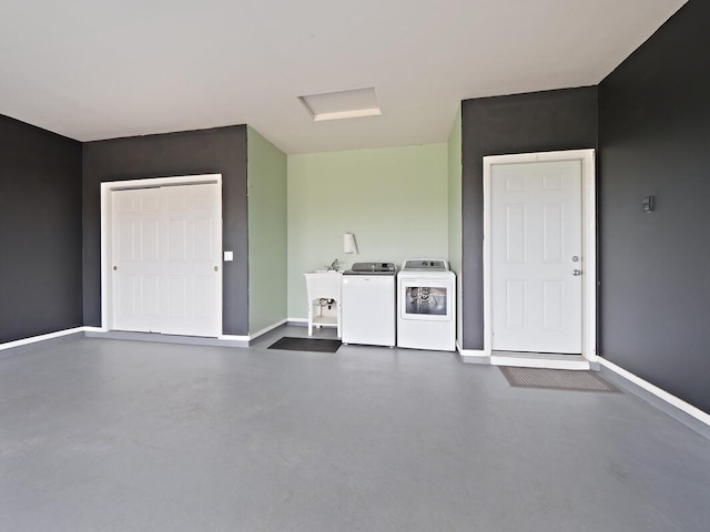 garage featuring washing machine and dryer and sink