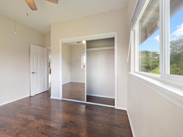 unfurnished bedroom with ceiling fan, a closet, and dark hardwood / wood-style floors