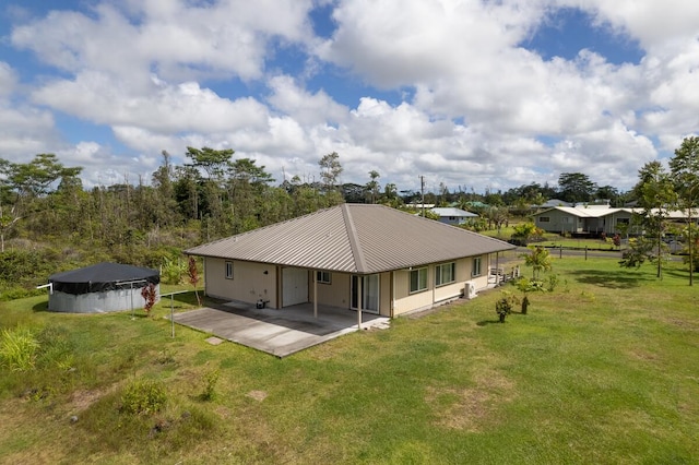 rear view of property featuring a lawn and a patio