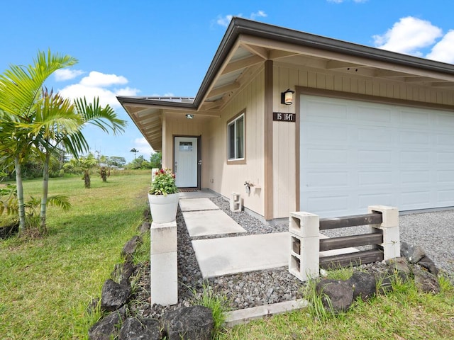 property entrance featuring a garage and a yard