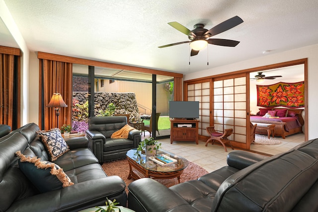 living room featuring a textured ceiling, light tile patterned floors, and plenty of natural light