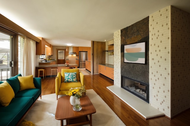 living room featuring a large fireplace and wood-type flooring