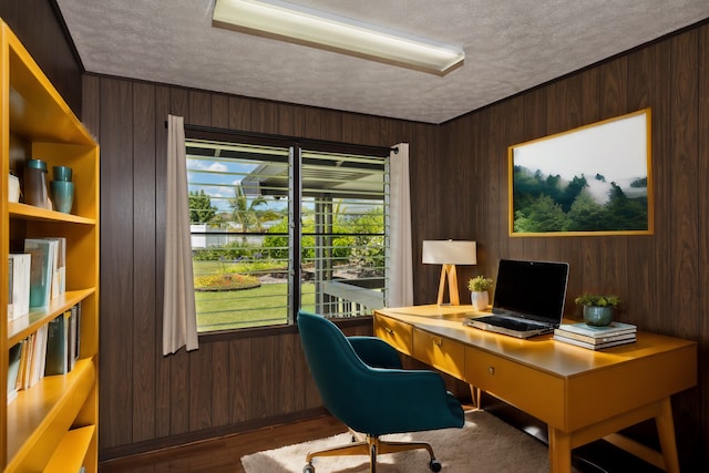 office featuring wood walls and a textured ceiling