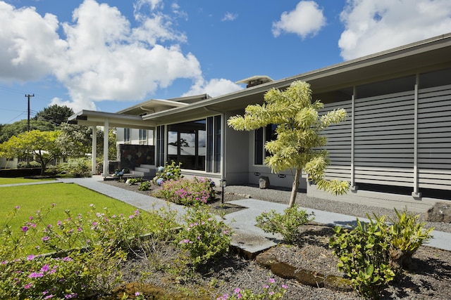 doorway to property featuring a lawn