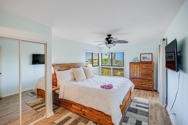 bedroom with ceiling fan, light wood-type flooring, and a closet