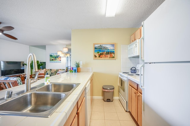 kitchen featuring tile countertops, white appliances, sink, light tile patterned floors, and tasteful backsplash