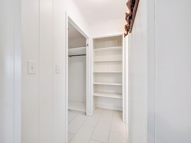 walk in closet with light tile patterned floors